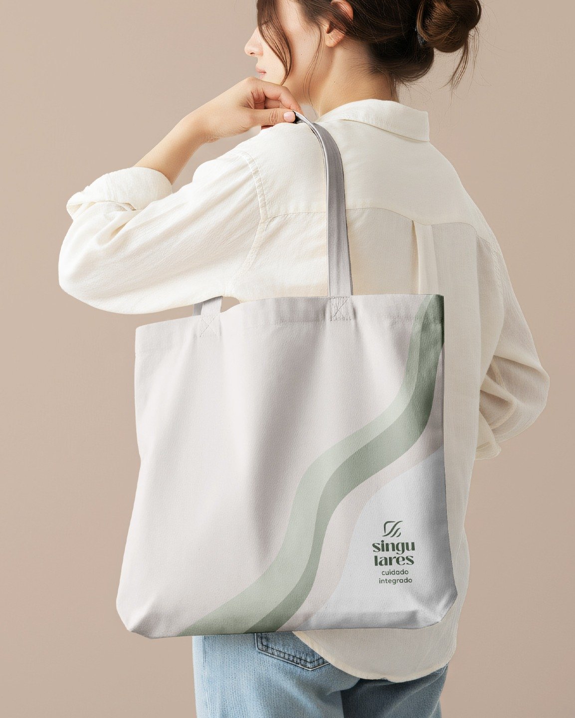 White tote bag with green graphics and the Singulares Cuidado Integrado logo